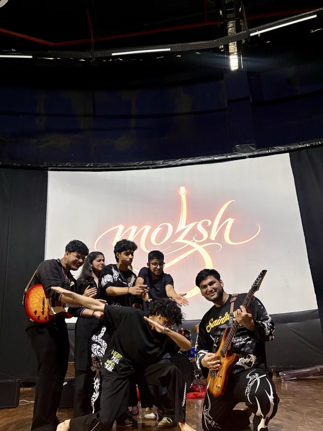 Hariank playing electric guitar on stage alongside the rest of the band.